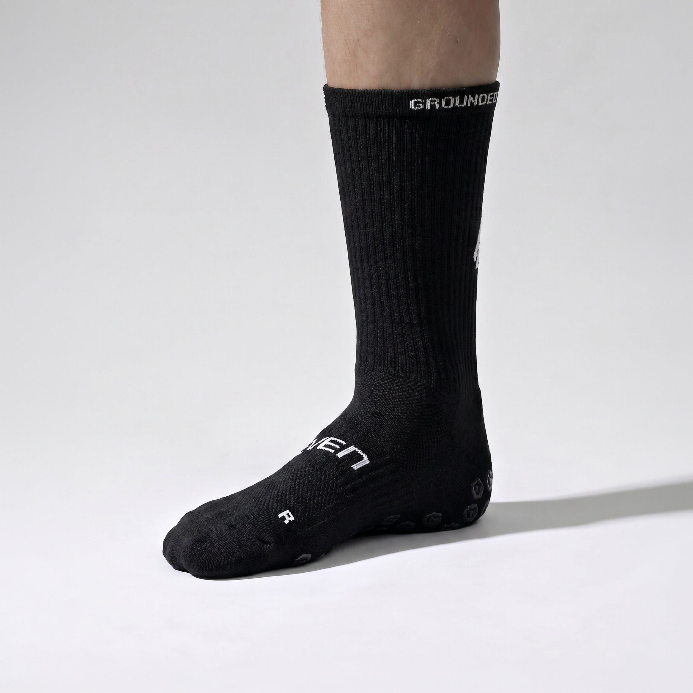 Seven junior black grip performance socks, inner side view with R marker