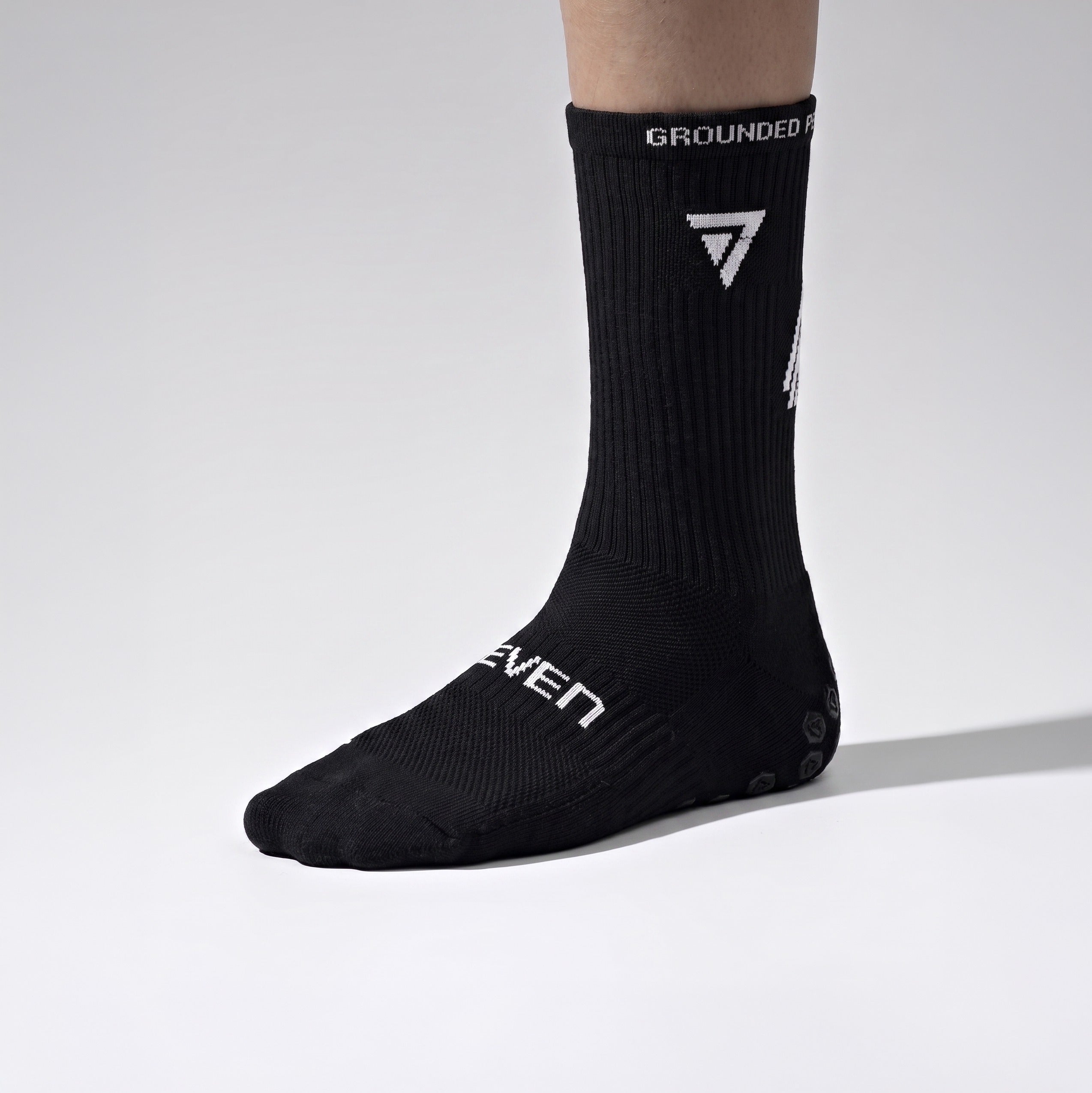 Seven junior black grip performance socks, outside view with SEVEN wordmark