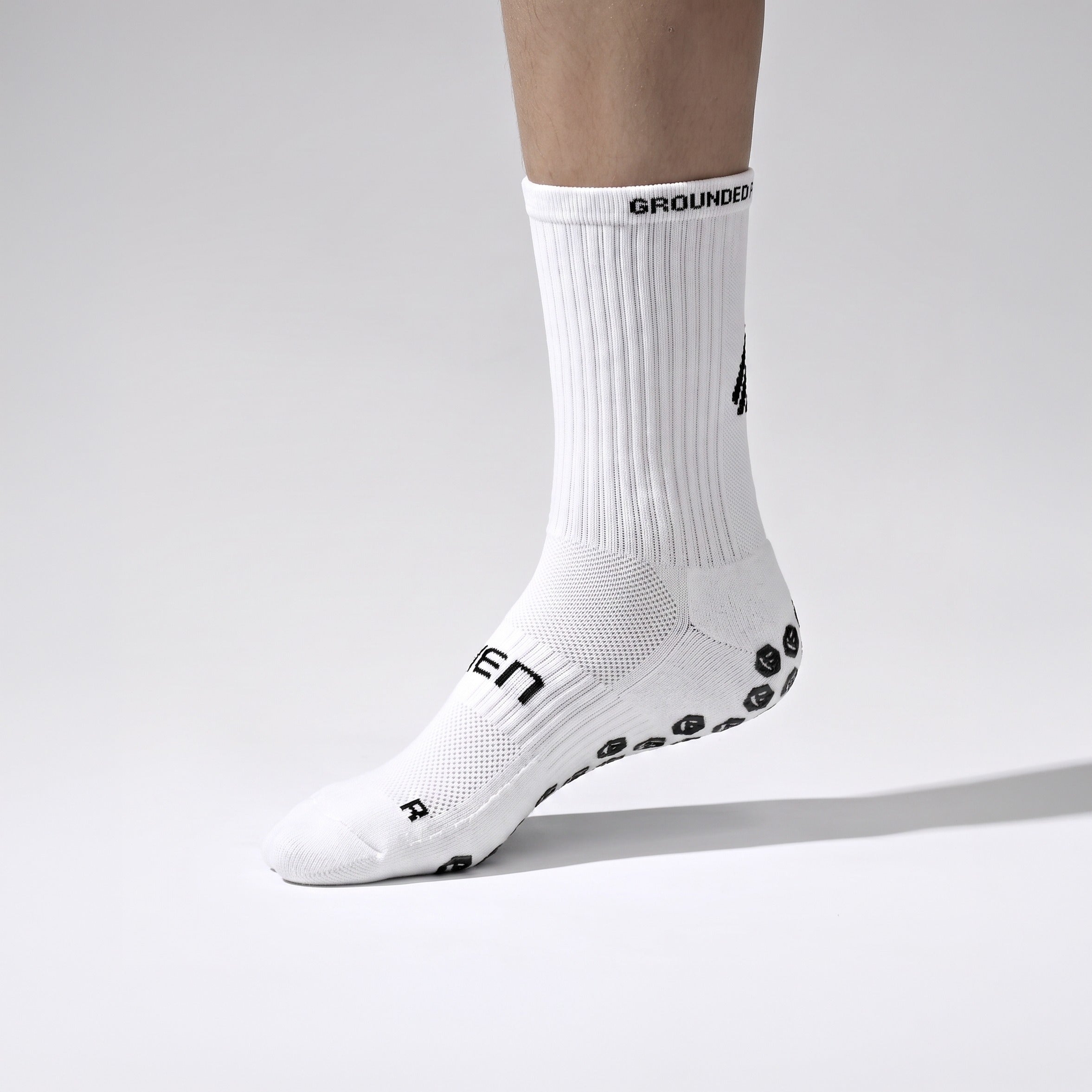 Seven junior white grip performance socks, inner side view with R marker
