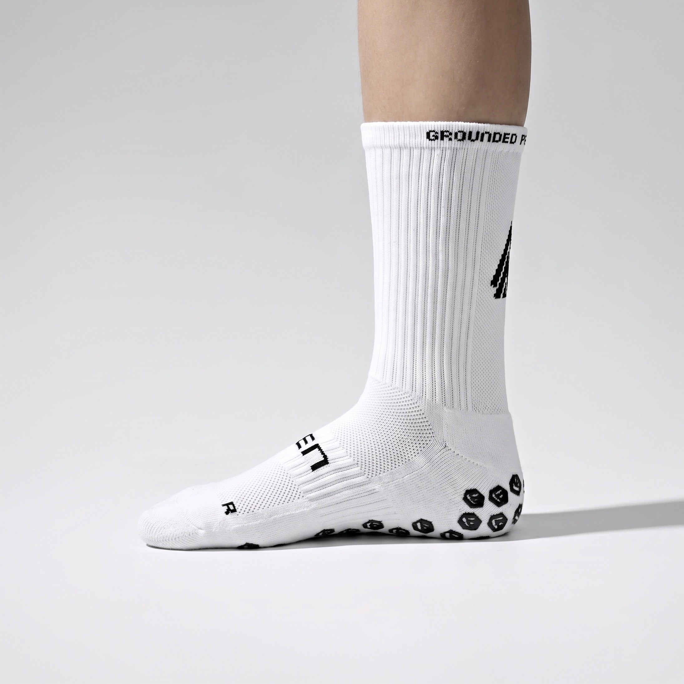 Seven junior white grip performance socks, outside view with SEVEN wordmark