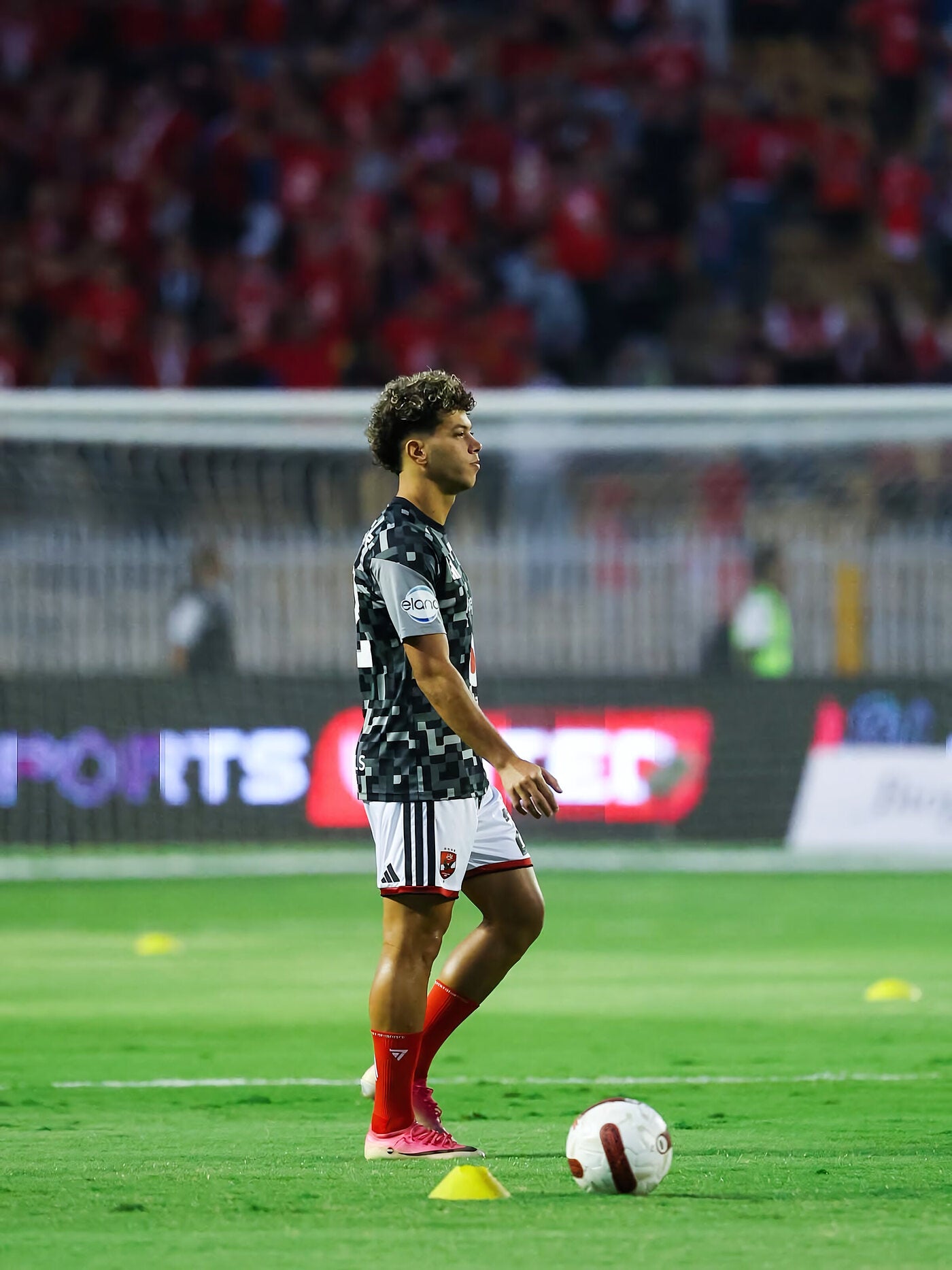 Professional footballer warming up before a match in red Seven performance socks