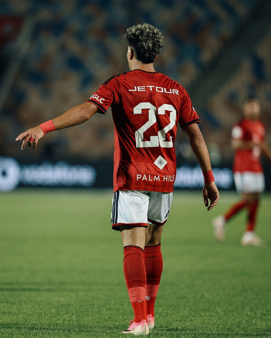 Professional footballer in a league match wearing red Seven performance socks
