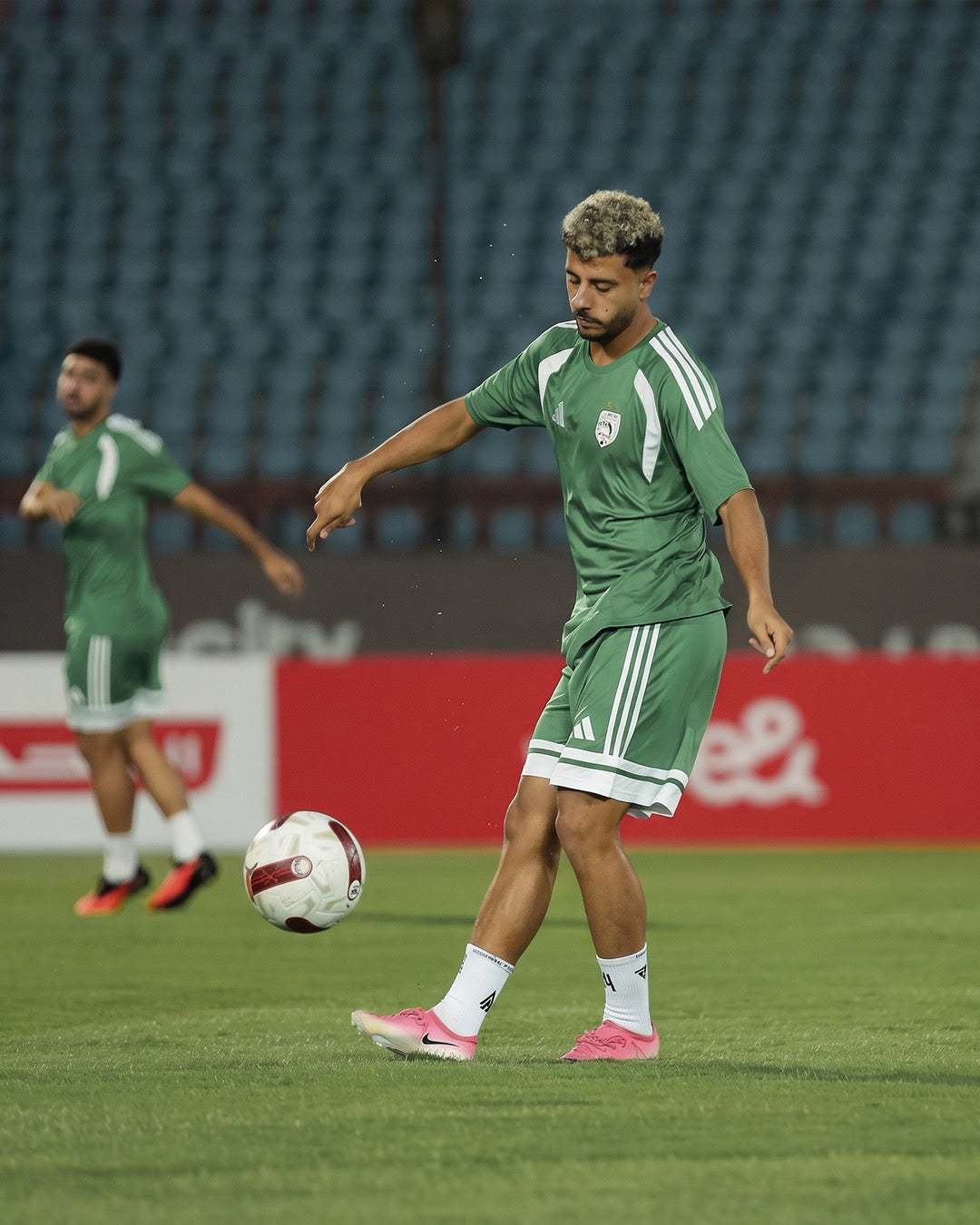 Professional footballer passing in a stadium training session in white Seven performance socks