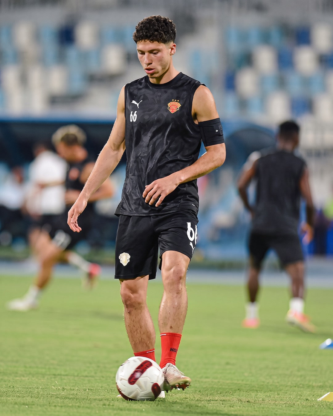Professional footballer in training in red Seven performance socks