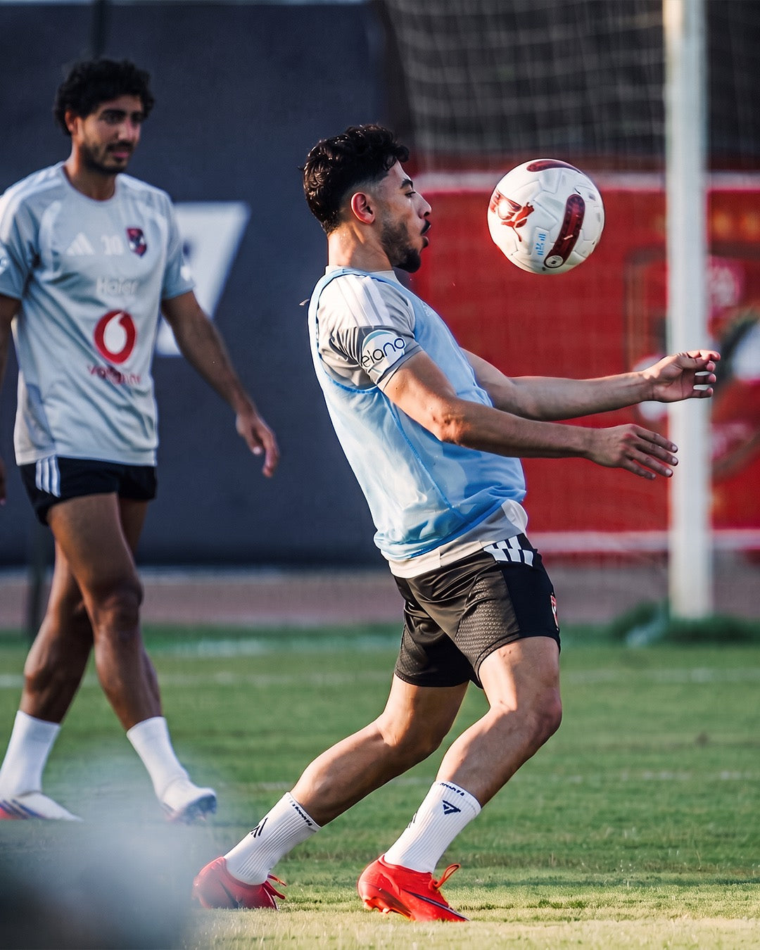 Professional footballer controlling the ball in training in white Seven performance socks