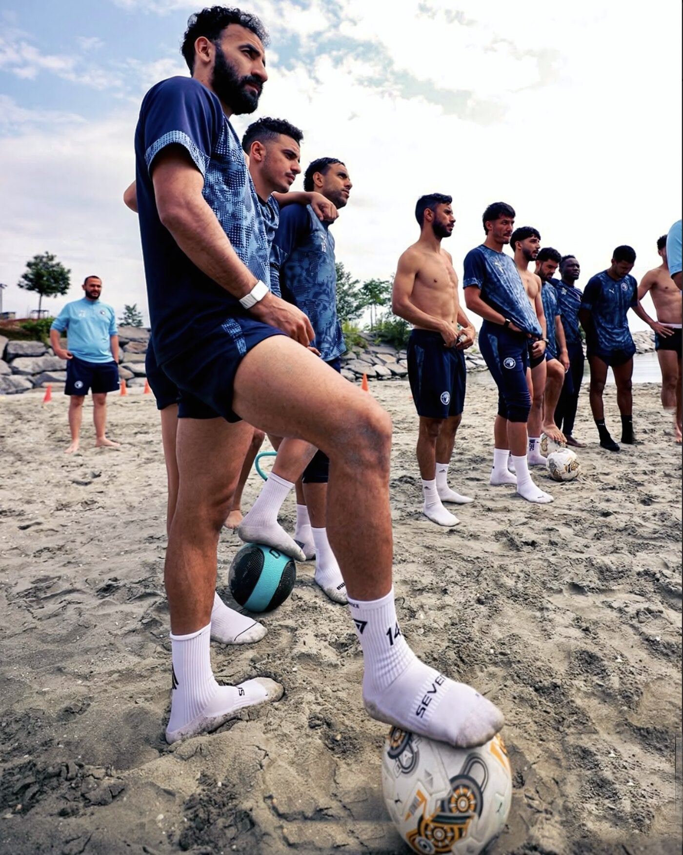 Professional footballers in beach training wearing white Seven performance socks